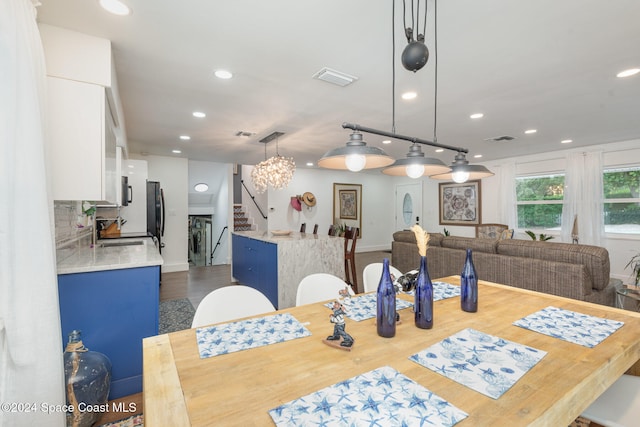 dining space with hardwood / wood-style flooring, sink, and a chandelier