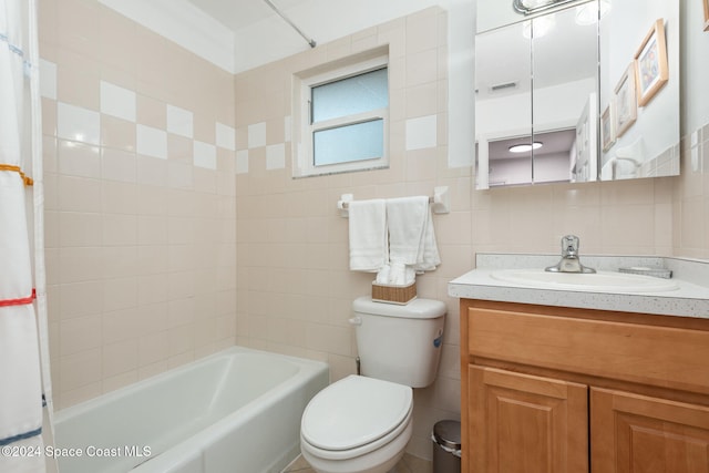 full bathroom featuring vanity, toilet, and tile walls