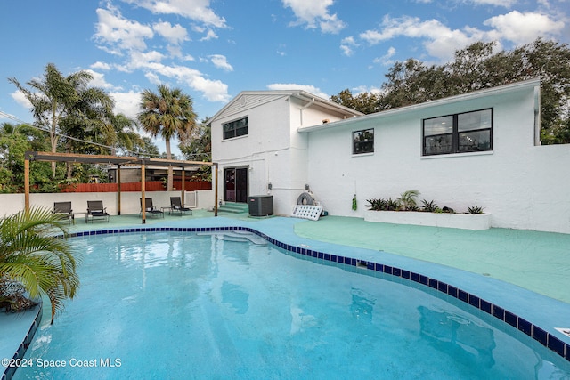 view of pool with cooling unit and a patio