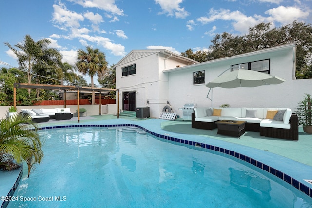 rear view of property with a patio area, a fenced in pool, an outdoor hangout area, and central AC