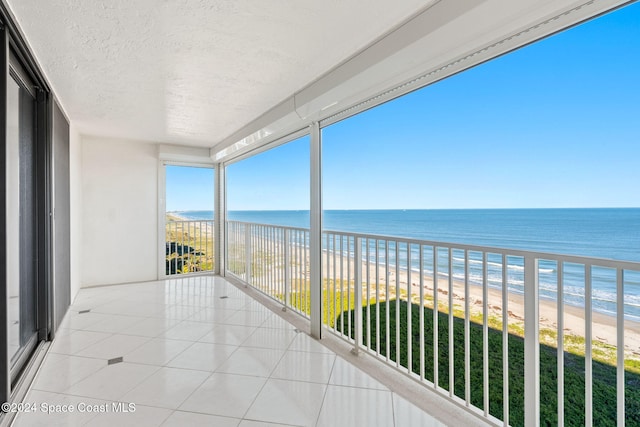 balcony with a water view and a beach view