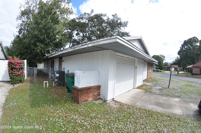 view of side of home with a garage and a lawn