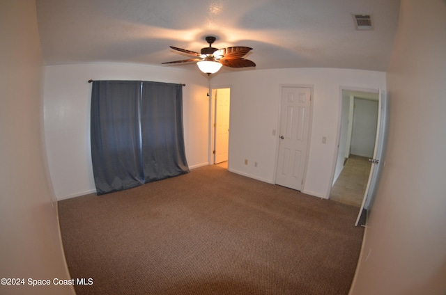 spare room with vaulted ceiling, carpet, and ceiling fan