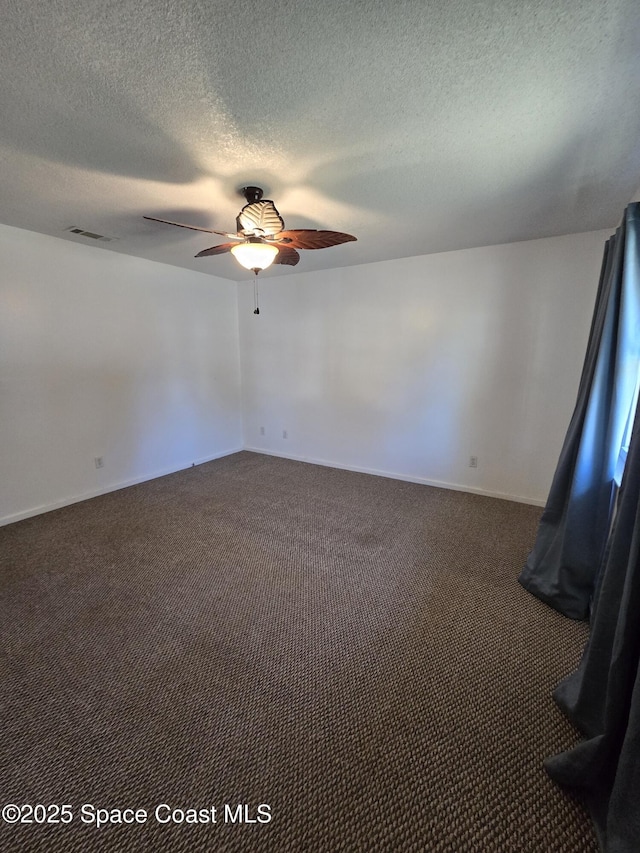 carpeted spare room with a textured ceiling and ceiling fan