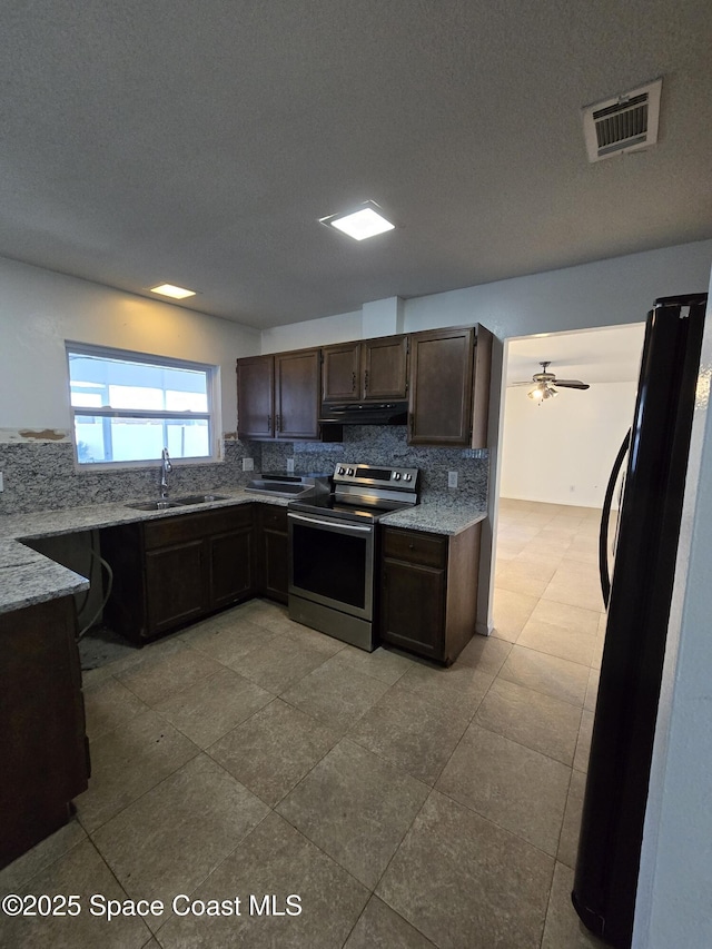 kitchen featuring dark brown cabinetry, sink, tasteful backsplash, stainless steel electric range oven, and black refrigerator