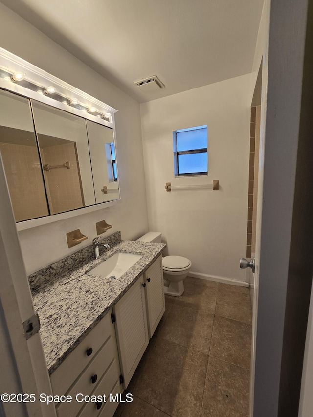 bathroom featuring vanity, tile patterned flooring, and toilet