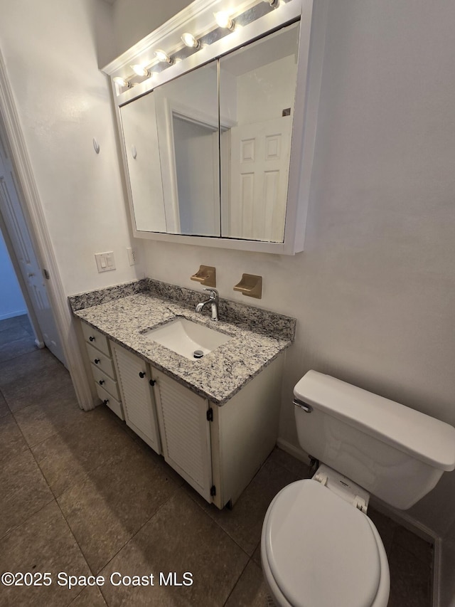 bathroom with tile patterned flooring, vanity, and toilet