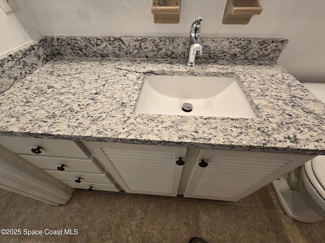 bathroom with vanity, toilet, and tile patterned flooring