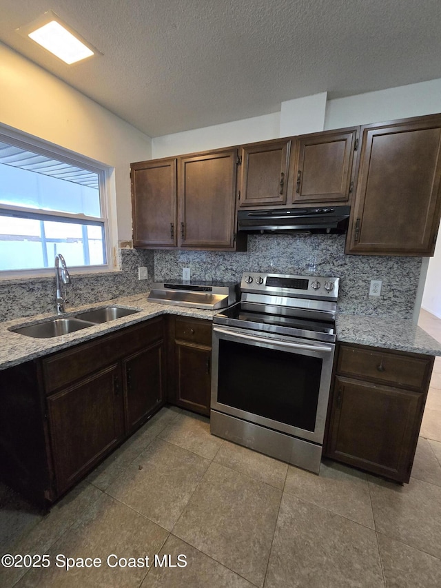 kitchen featuring sink, stainless steel range with electric stovetop, light stone countertops, a textured ceiling, and decorative backsplash