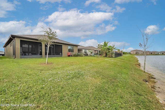 view of yard with a sunroom and a water view