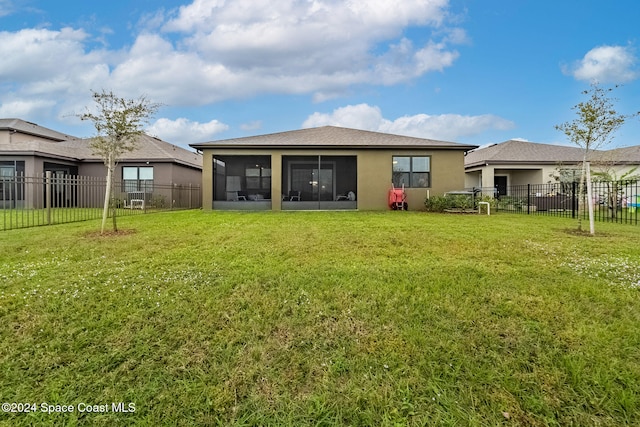 back of property with a sunroom and a lawn