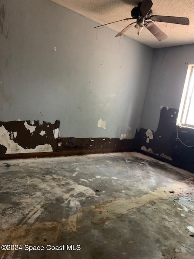 unfurnished room featuring ceiling fan and a textured ceiling