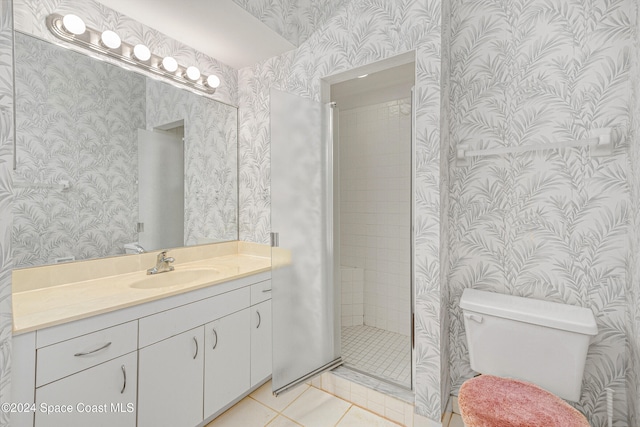 bathroom featuring tile patterned flooring, vanity, toilet, and tiled shower