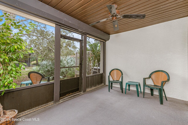 sunroom featuring ceiling fan and wood ceiling