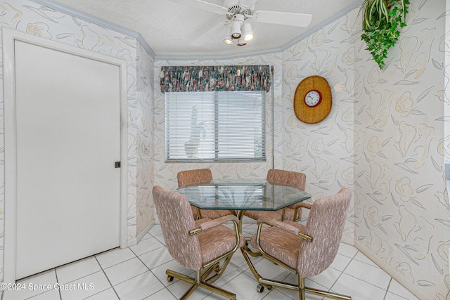 tiled dining area with ceiling fan, a textured ceiling, and ornamental molding