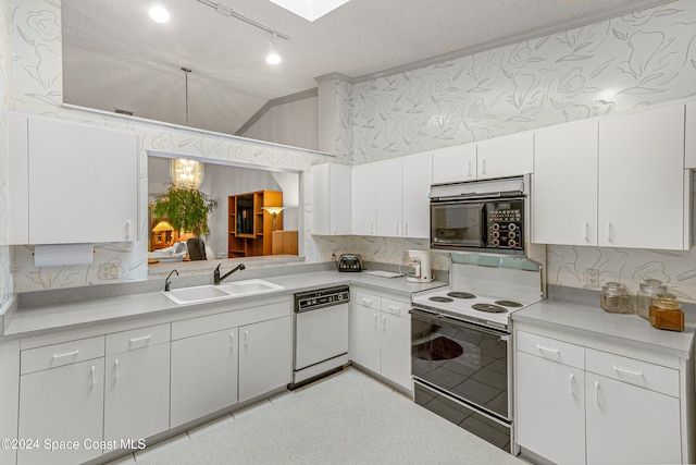 kitchen with white cabinetry, sink, lofted ceiling with skylight, and white appliances