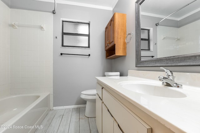 full bathroom with vanity, tiled shower / bath, toilet, ornamental molding, and wood-type flooring