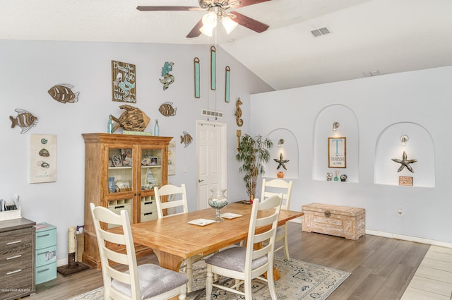 dining room with ceiling fan, light wood-type flooring, and lofted ceiling