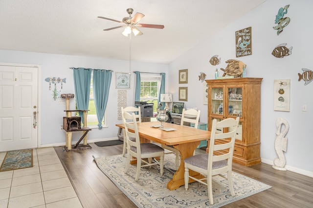 dining space featuring wood-type flooring, vaulted ceiling, and ceiling fan