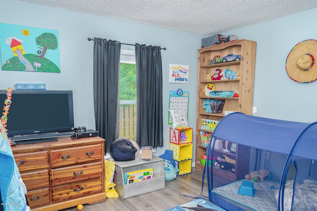 bedroom with light hardwood / wood-style floors and a textured ceiling