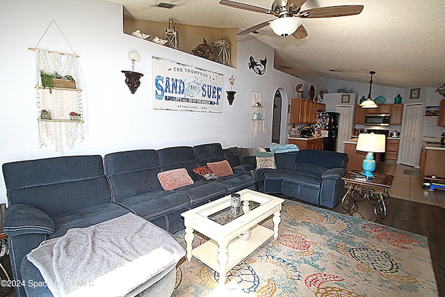 living room featuring a textured ceiling, ceiling fan, hardwood / wood-style floors, and vaulted ceiling