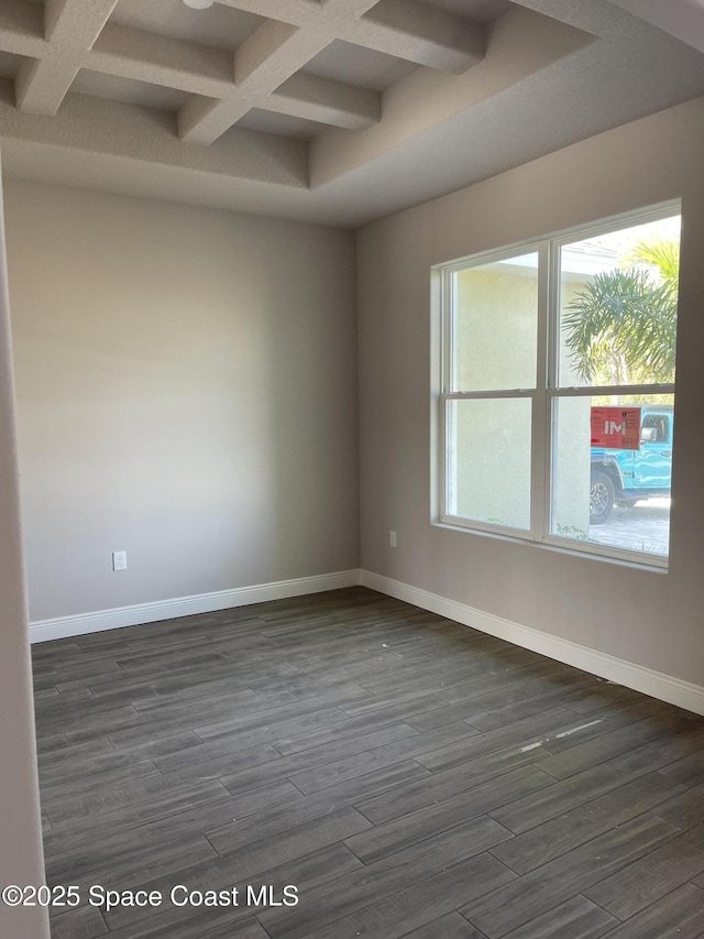 empty room featuring beam ceiling, dark hardwood / wood-style flooring, and coffered ceiling