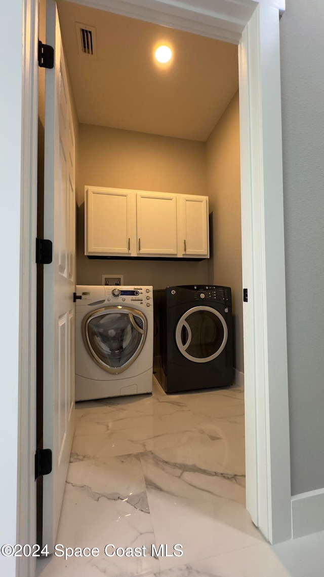 washroom featuring cabinets and separate washer and dryer