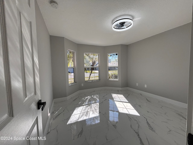 spare room with a textured ceiling