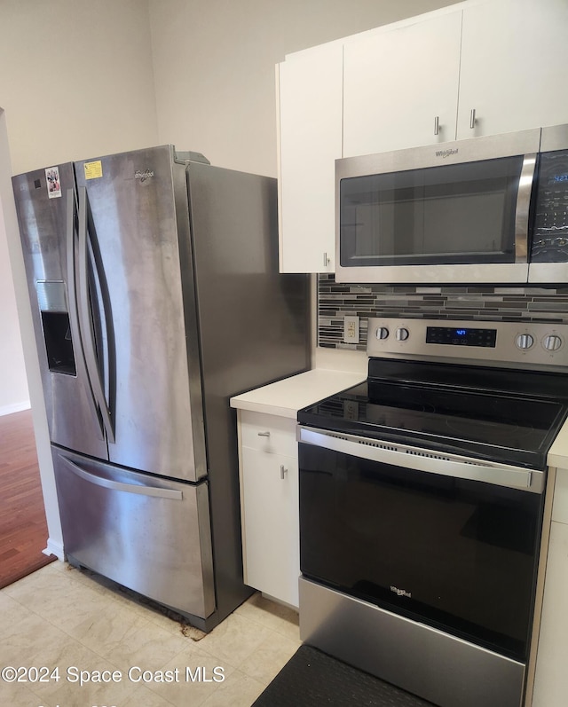 kitchen featuring decorative backsplash, light wood-type flooring, white cabinetry, and stainless steel appliances