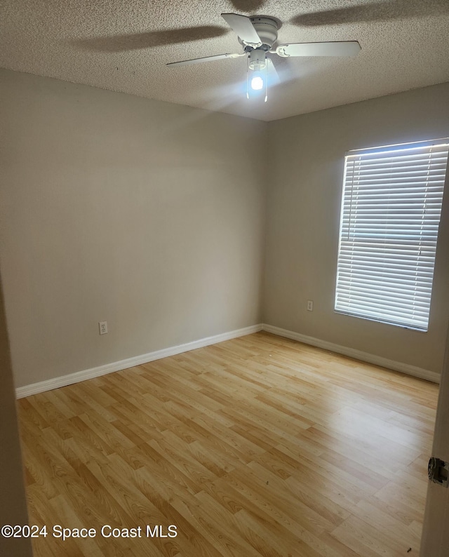 unfurnished room with ceiling fan, a textured ceiling, and light hardwood / wood-style flooring