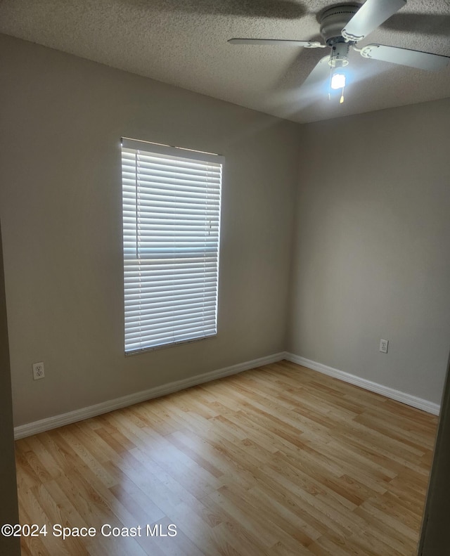 spare room featuring a textured ceiling, light hardwood / wood-style floors, and ceiling fan