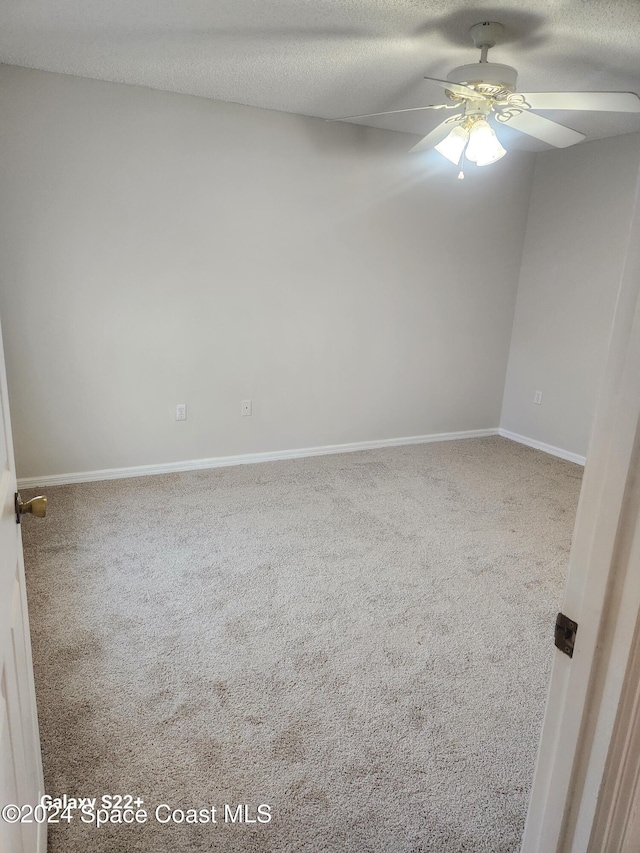 unfurnished room with ceiling fan, carpet floors, and a textured ceiling