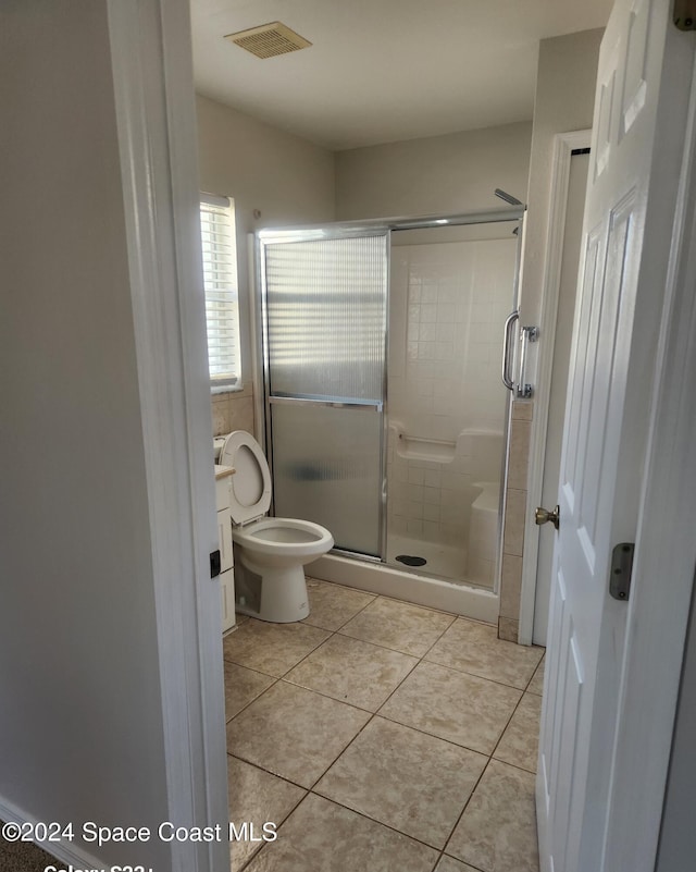 bathroom with tile patterned floors, toilet, and walk in shower