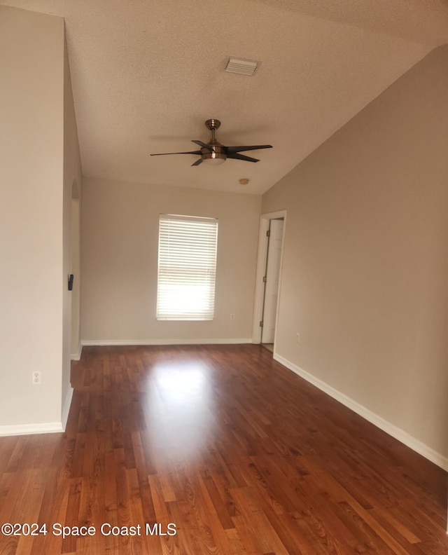 unfurnished room with a textured ceiling, dark hardwood / wood-style flooring, ceiling fan, and lofted ceiling