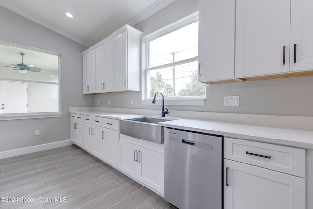 kitchen featuring stainless steel dishwasher, vaulted ceiling, crown molding, sink, and white cabinets