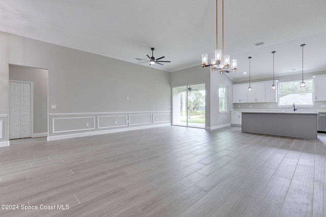 unfurnished living room featuring ceiling fan with notable chandelier, light hardwood / wood-style flooring, ornamental molding, and sink