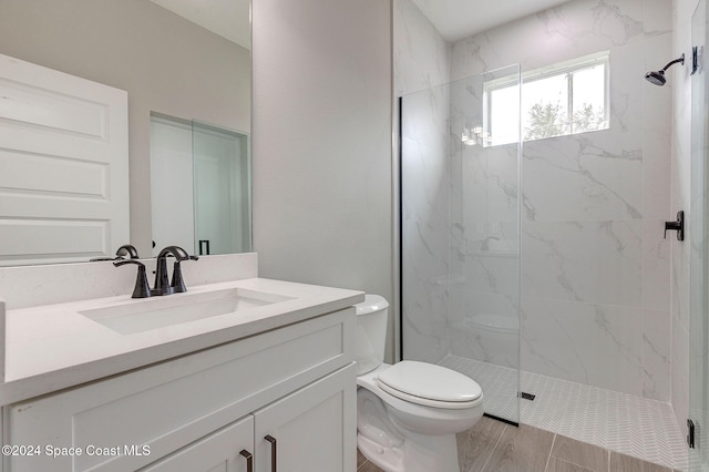 bathroom with hardwood / wood-style floors, vanity, toilet, and an enclosed shower