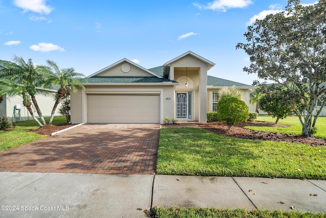 single story home featuring a garage and a front yard