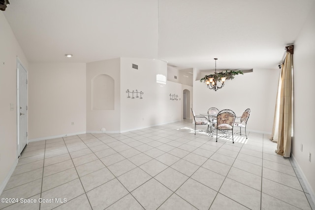 unfurnished dining area featuring light tile patterned flooring and an inviting chandelier