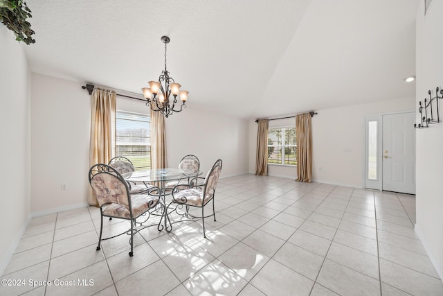 dining area with light tile patterned floors, an inviting chandelier, and vaulted ceiling