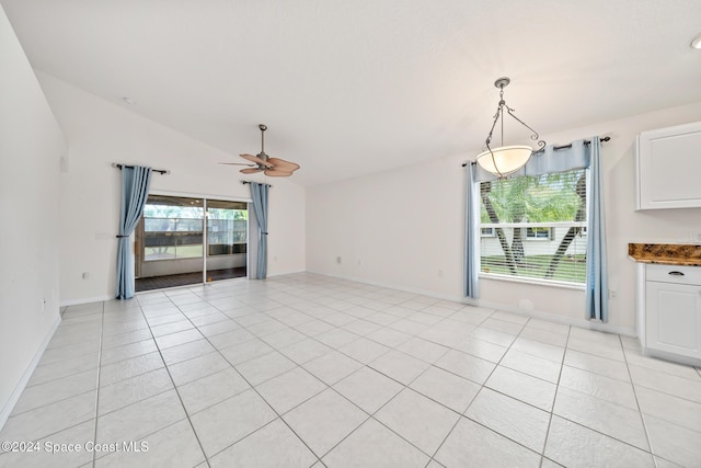 interior space featuring ceiling fan, light tile patterned floors, and vaulted ceiling