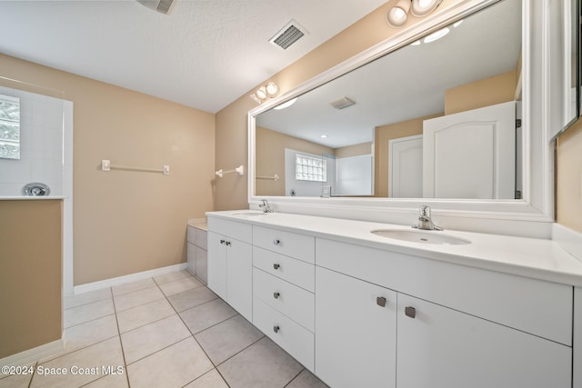 bathroom featuring tile patterned flooring, a textured ceiling, and vanity