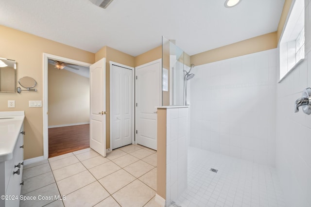 bathroom featuring a tile shower, vanity, ceiling fan, and hardwood / wood-style floors