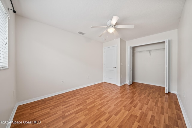 unfurnished bedroom with a closet, ceiling fan, and light hardwood / wood-style flooring