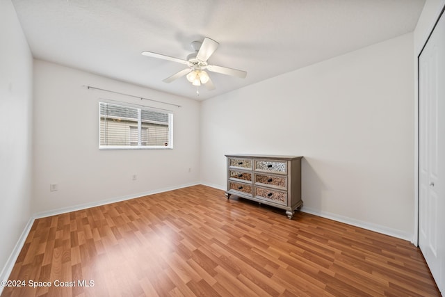 unfurnished bedroom featuring hardwood / wood-style floors, ceiling fan, and a closet