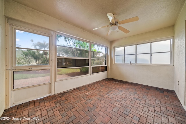 unfurnished sunroom with ceiling fan