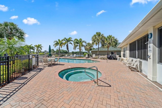 view of swimming pool featuring a patio area and a hot tub