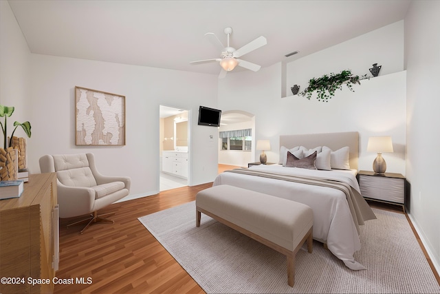 bedroom featuring ensuite bath, ceiling fan, hardwood / wood-style floors, and vaulted ceiling