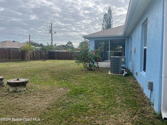 view of yard featuring a sunroom, an outdoor fire pit, and central air condition unit