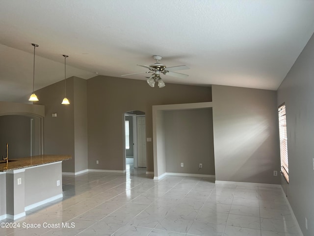 unfurnished room with vaulted ceiling, ceiling fan, and sink